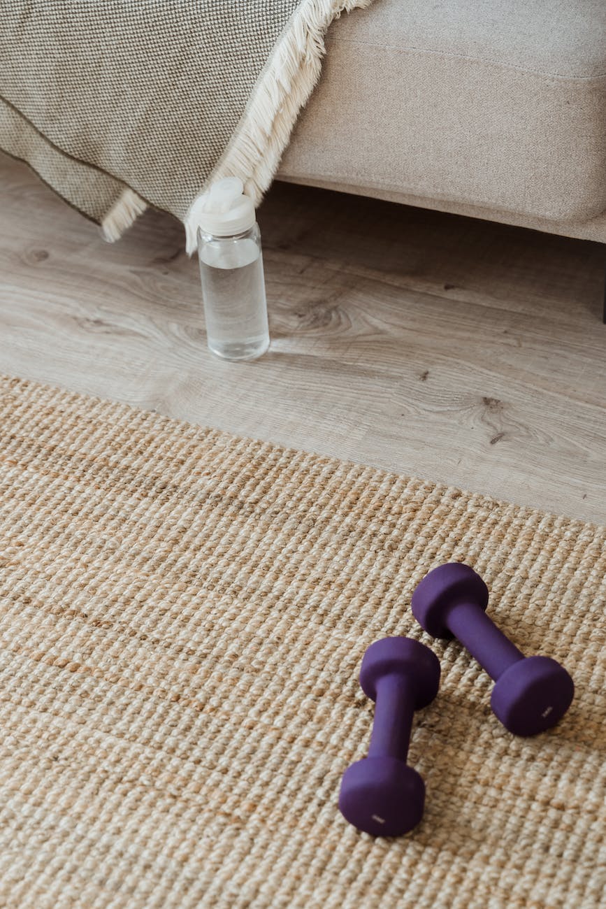 dumbbells and a water bottle on the floor