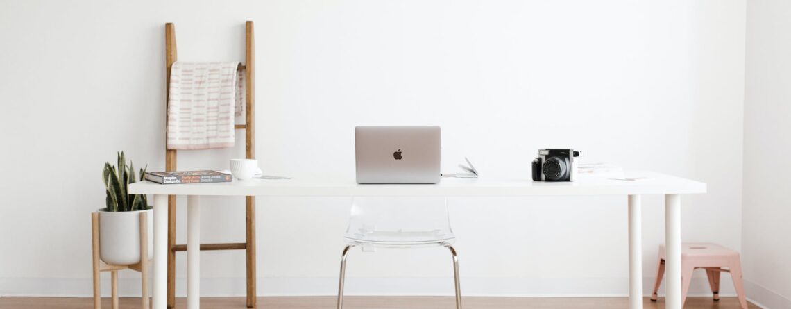 silver macbook on white table